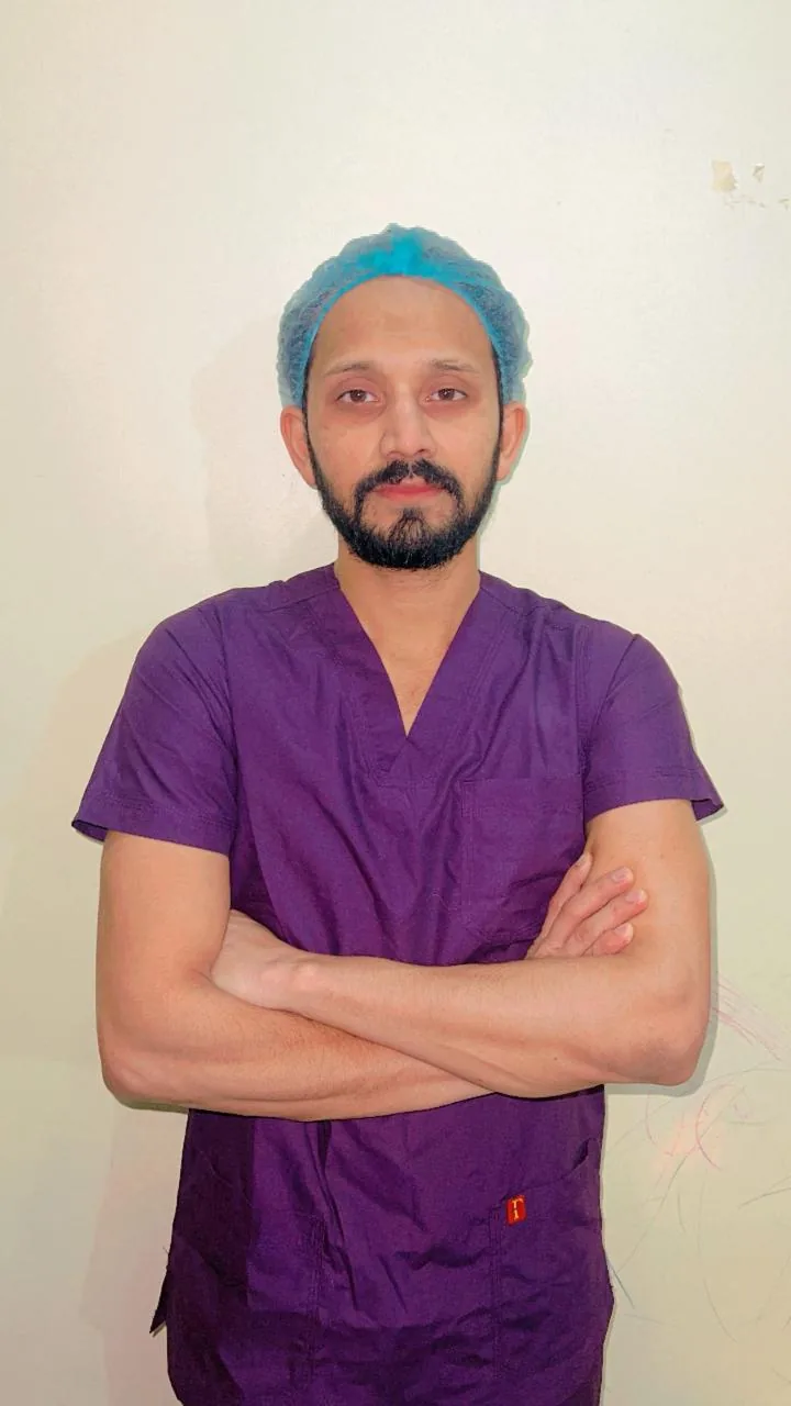Dr. Abu Ammar Rizvi in surgical scrubs and cap