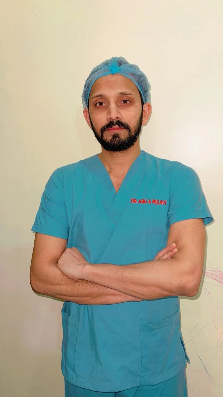 Dr. Abu Ammar Rizvi in teal theatre scrubs