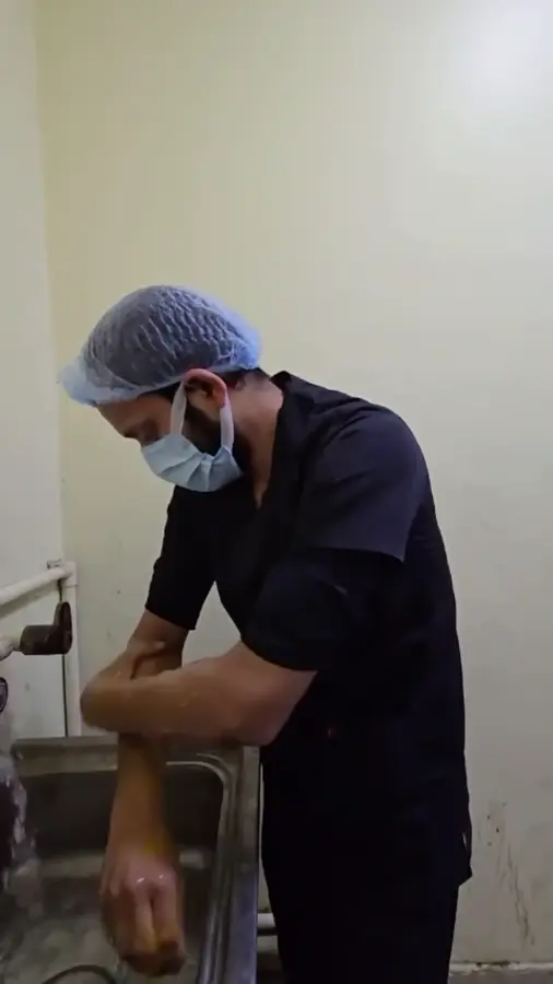 Dr. Rizvi scrubbing his hands before an operation